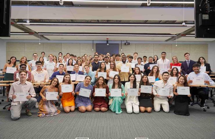 A group of students proudly displaying their certificates in a classroom setting.