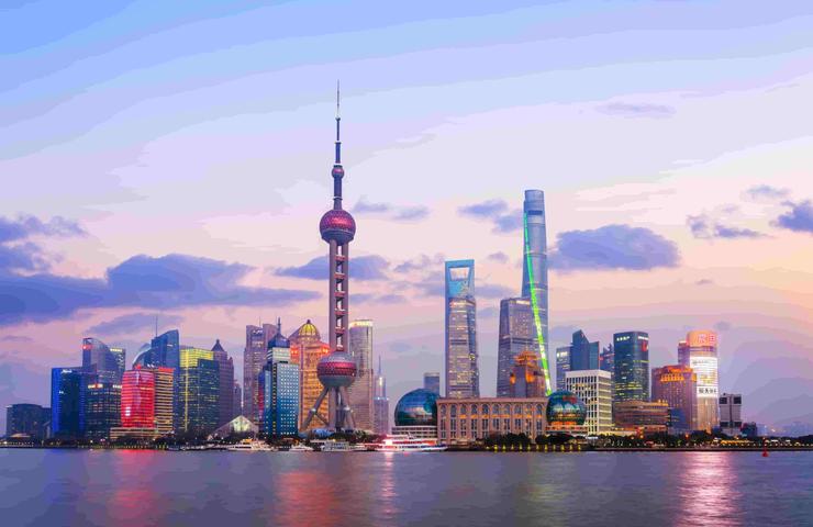 A vibrant skyline of Shanghai illuminated at sunset.