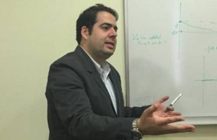 Man giving a presentation next to a whiteboard with diagrams.