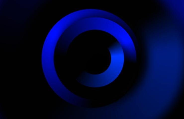 A circular abstract design featuring shades of blue on a dark background.