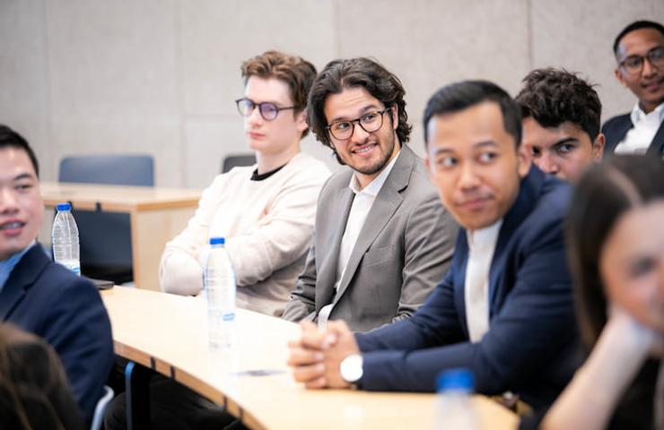 A group of diverse people sitting in a conference room, smiling at the camera.