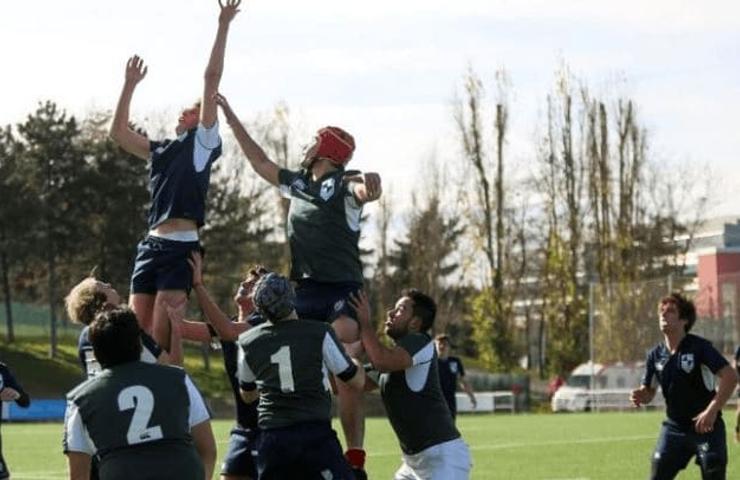 Two rugby teams engaging in a lineout during a match on a sunny day.