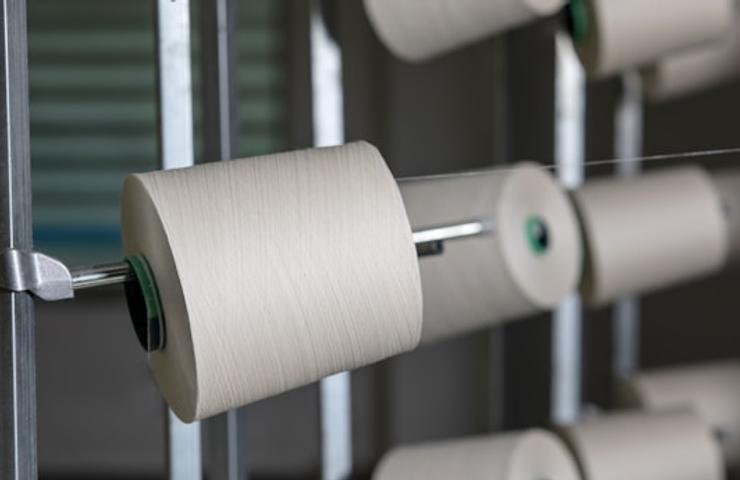 A close-up view of spools of thread on a rack.