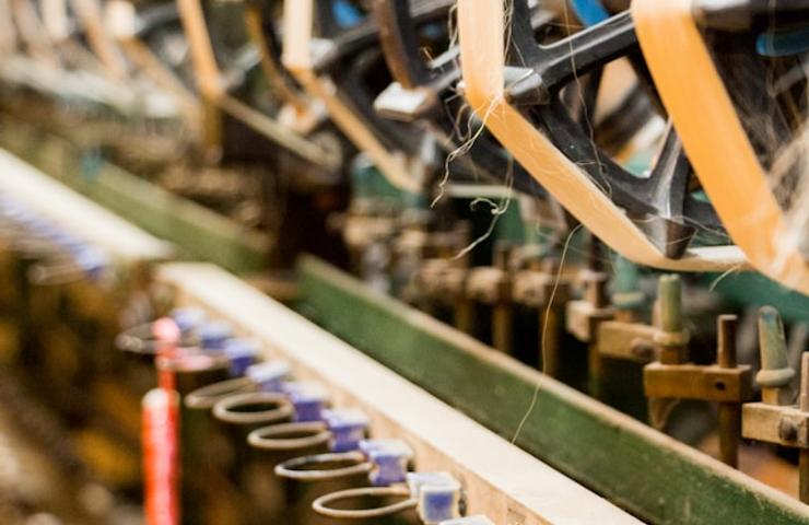 A close-up view of machinery with reels and components in a workshop.