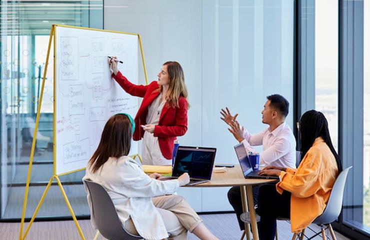 A diverse group of professionals engaged in a presentation in a modern office setting