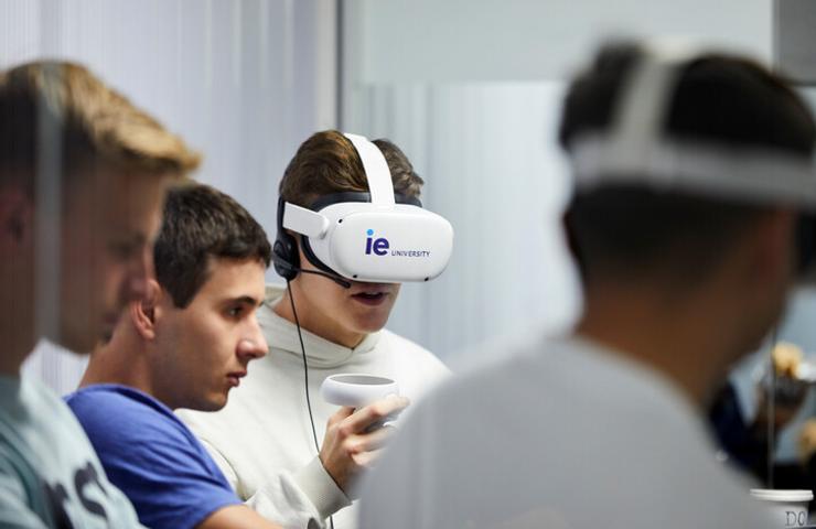 A group of young men are engaging with virtual reality headsets in a modern educational setting.