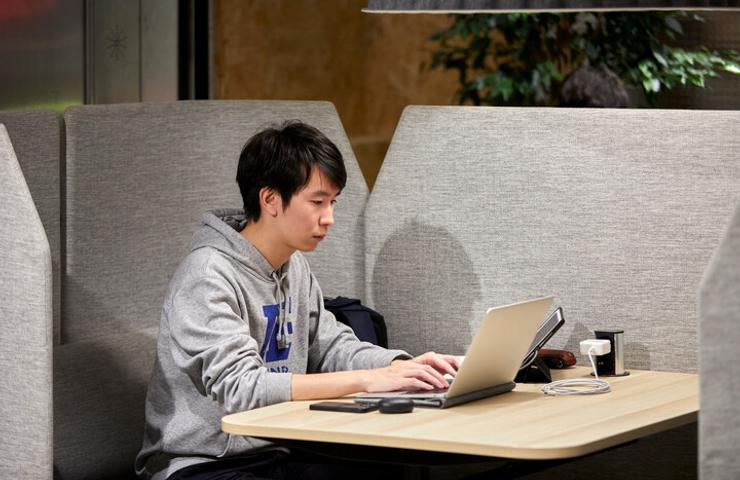 A young man using a laptop at a cafe table