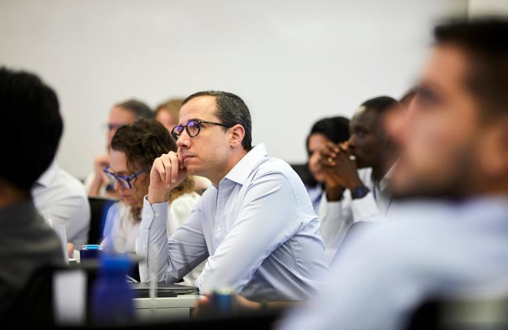 A diverse group of people attentively listening during a presentation.