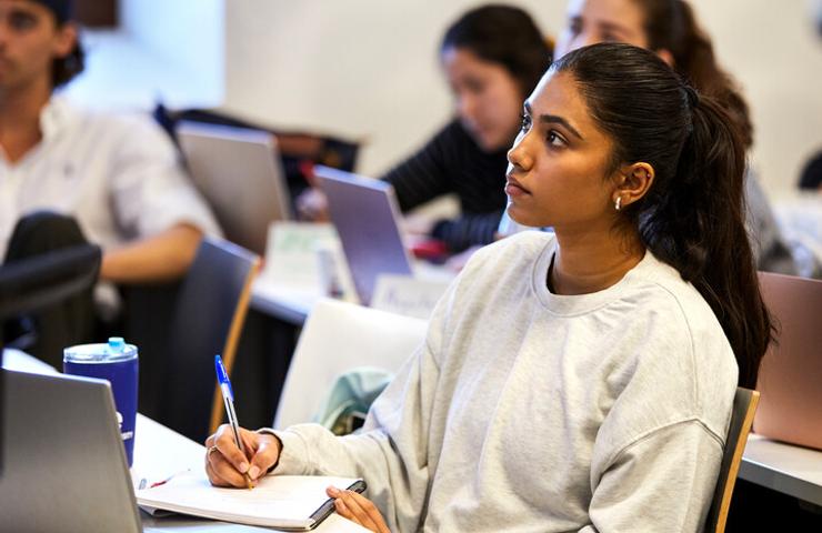 A student attentively listening in a classroom setting.