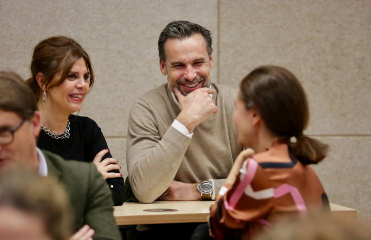 A group of three people engaged in a lively conversation at a table.