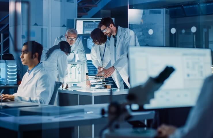 A group of scientists collaborating in a modern laboratory, analyzing data and discussing over a microscope.