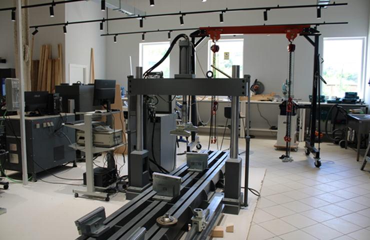 The image shows a modern workspace with various machinery and tools for technical work.
