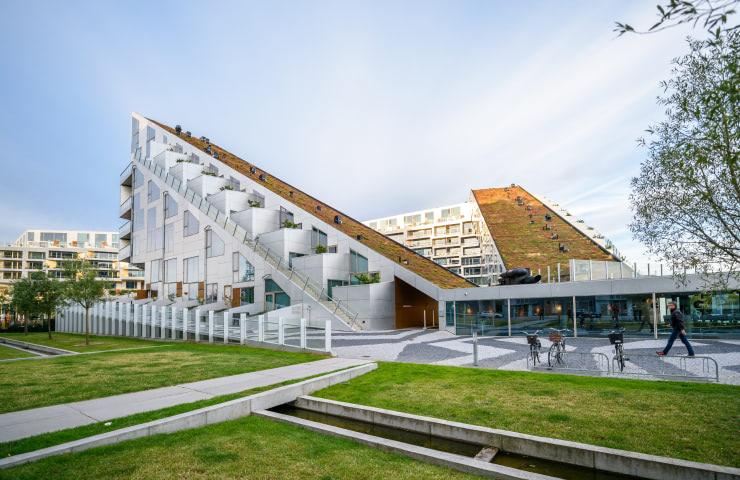 Modern architecture building with unique geometric design and pedestrians walking by.