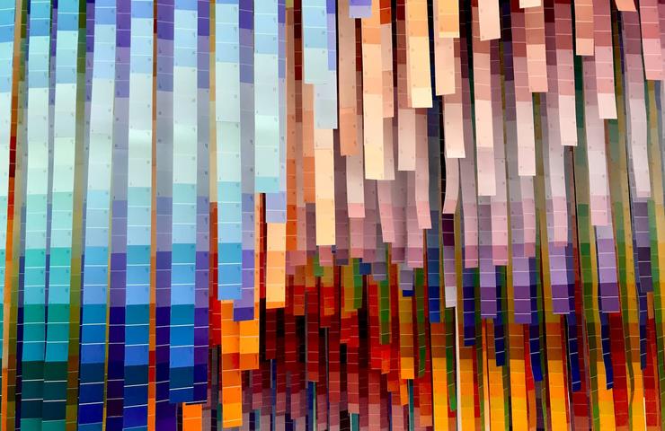 Abstract pixelated image with a blend of various vibrant colors arranged vertically.