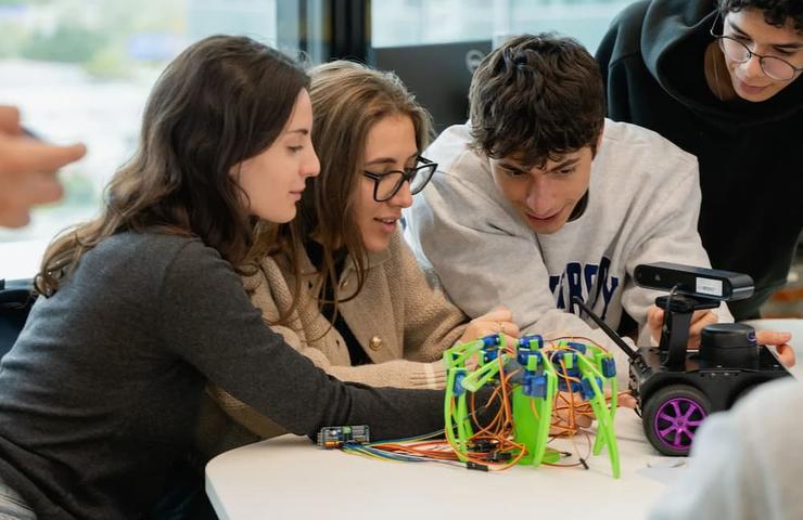 A group of students collaborating on a robotics project at a table.