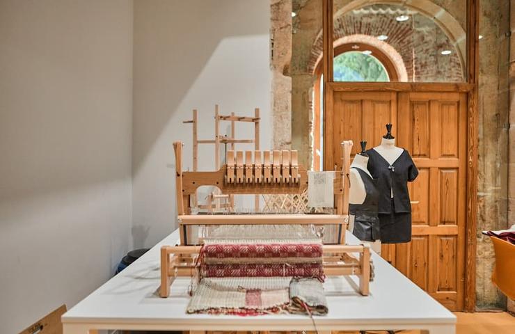 A weaving loom setup in a bright, artistic workspace.