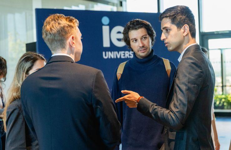 A group of young professionals engaged in a discussion at a university event.
