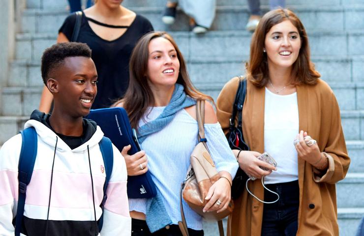 A group of young students happily descending stairs together