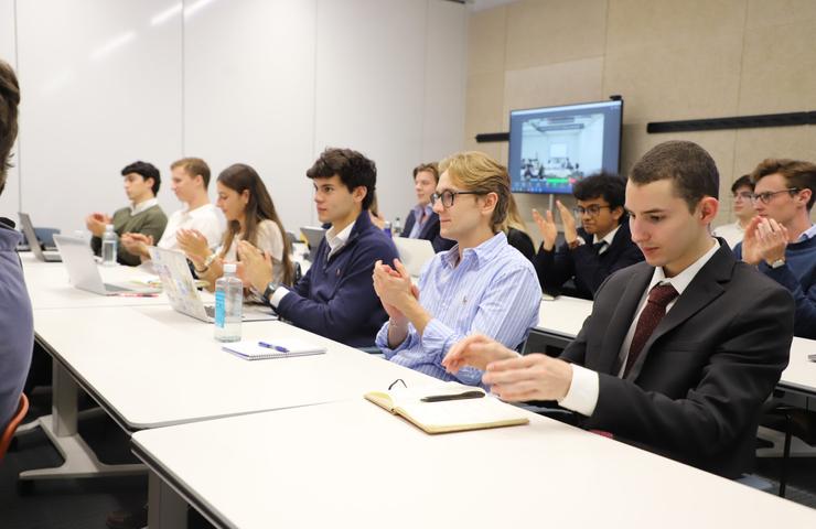 A group of students is applauding in a classroom setting.