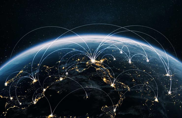 A digital depiction of the Earth from space showing illuminated cities connected by glowing arcs representing communication networks.