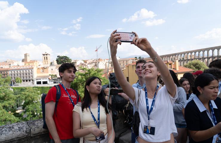 A group of young people taking a selfie with a scenic background.