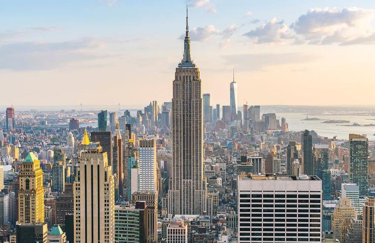 A panoramic view of New York City featuring the Empire State Building under a clear sky.