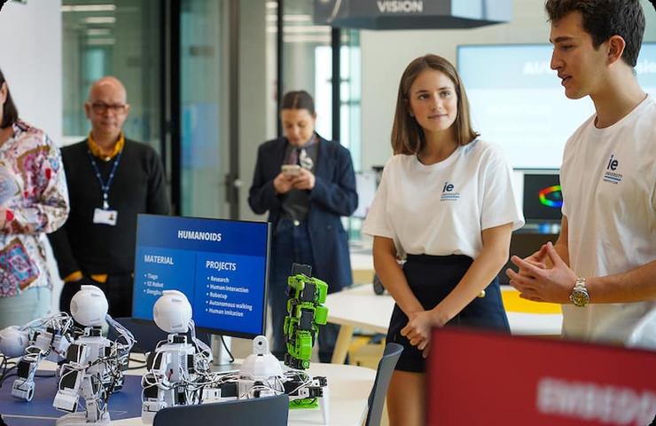 A team presents robotic projects in a modern workspace.