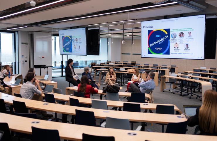A group of people in a seminar room discussing sustainability topics.