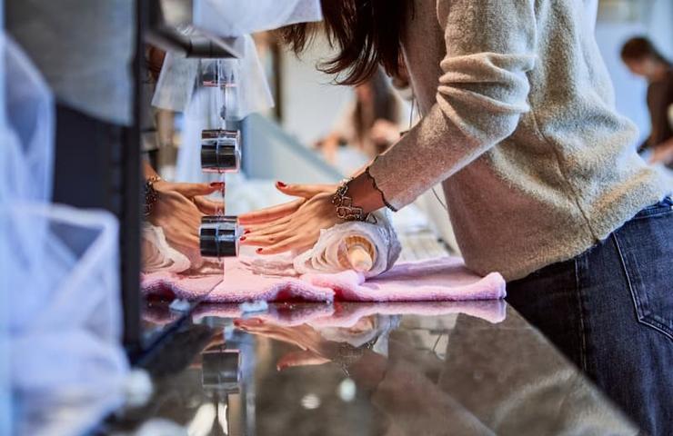 A person is preparing a pastry at a counter with various tools in a bright kitchen.