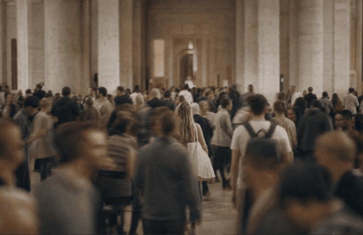 A busy public space filled with a crowd of people moving in different directions.
