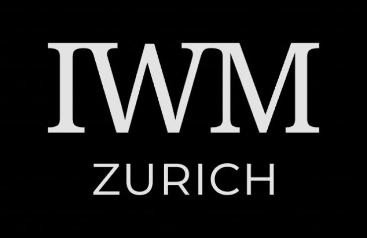 The image displays a logo with the letters 'IWM' and the word 'ZURICH' against a black background.