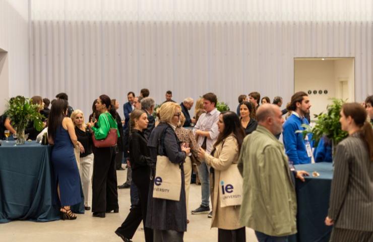 A bustling networking event at an indoor venue with many attendees engaged in conversation.