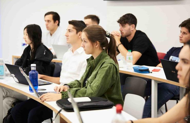 A group of students attentively listening in a classroom setting.