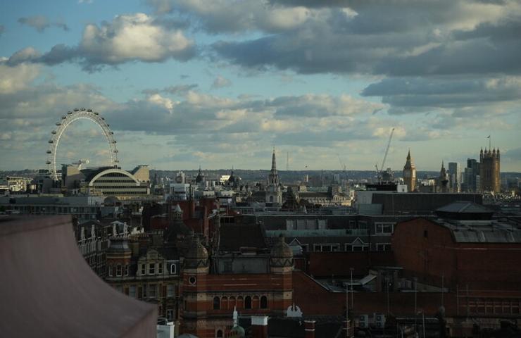 A panoramic view of London showcasing the skyline with notable landmarks under a cloudy sky.