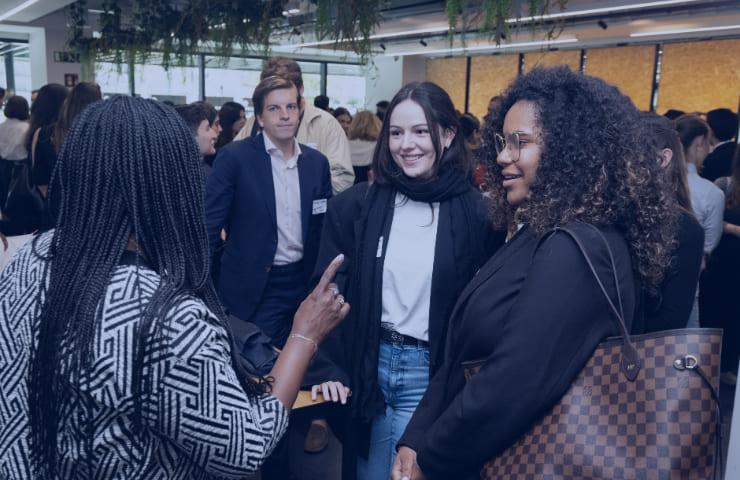 A group of people engaging in a conversation at a networking event.