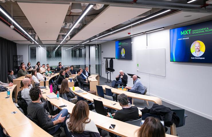 A group of people attending a seminar in a modern classroom setting.