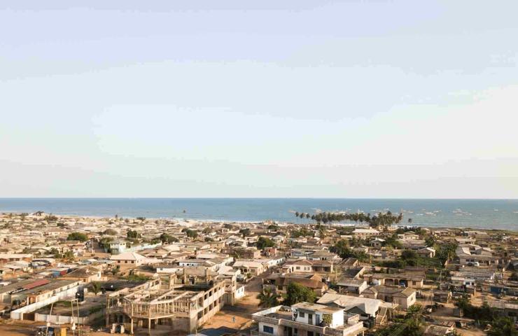 Aerial view of a coastal town with numerous buildings and distant views of the ocean.