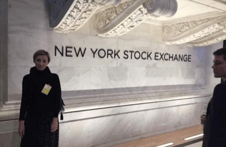 A woman and a man standing inside the New York Stock Exchange building.