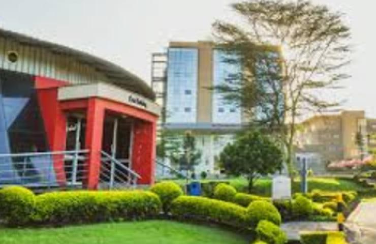 A modern educational building with landscaped gardens in the foreground.