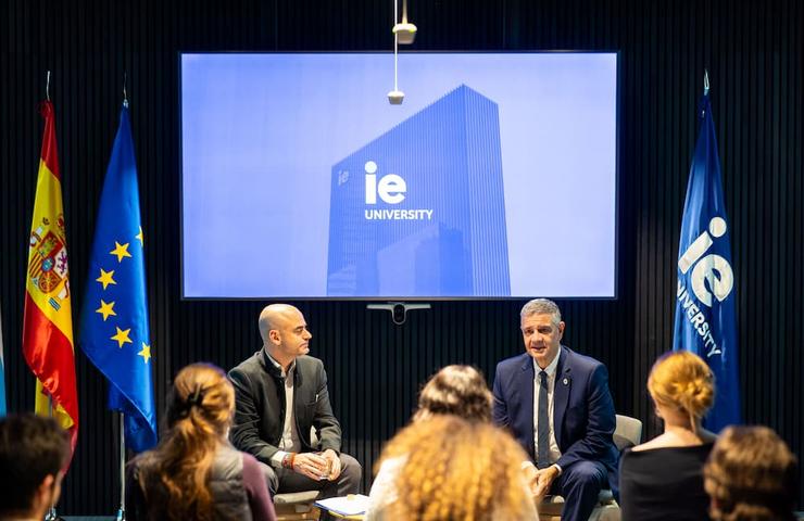 A discussion featuring speakers on stage at a university event.