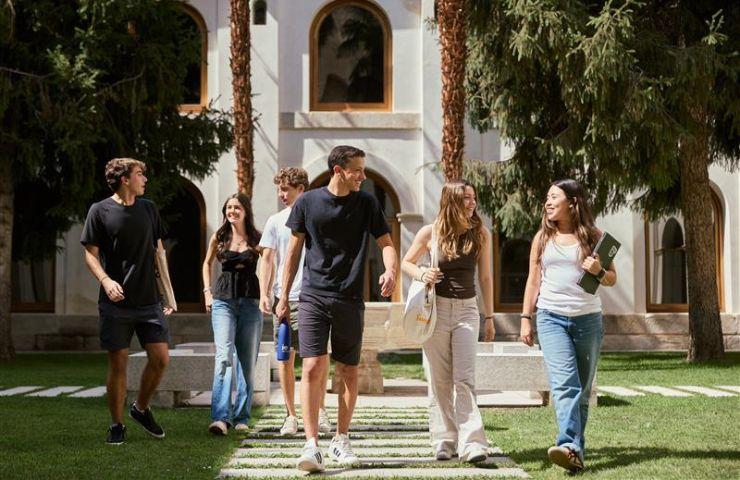 A group of young adults walking together in a sunny courtyard.