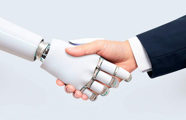 A human hand shaking hands with a robotic hand, symbolizing human-robot collaboration.