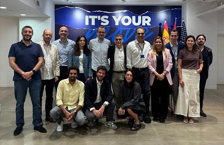 A diverse group of people standing together in a modern office setting.