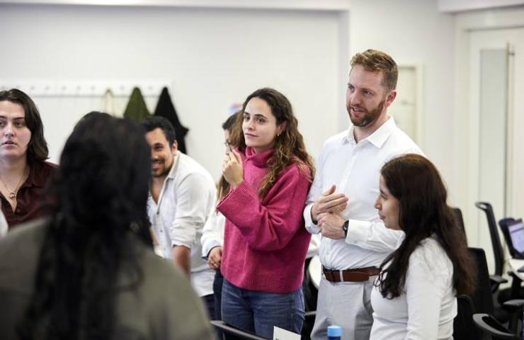 A group of people engaging in a conversation in a well-lit room.