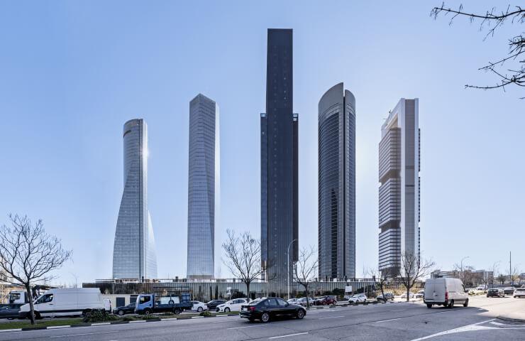 A cityscape featuring a series of tall, modern skyscrapers under a clear blue sky.