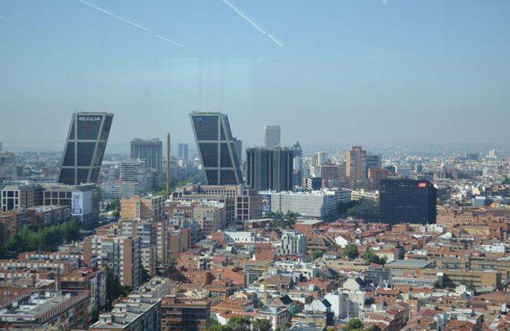 A panoramic view of a city skyline featuring modern skyscrapers and residential buildings.