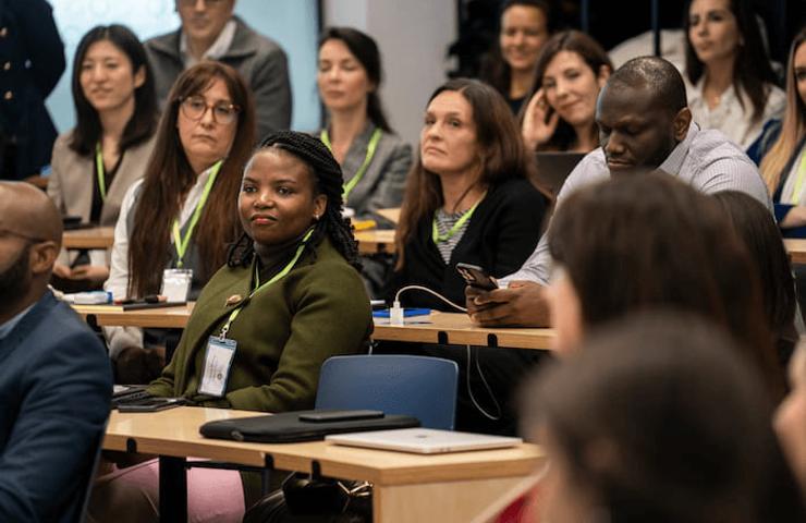 A group of diverse people attentively listening at a conference or seminar.