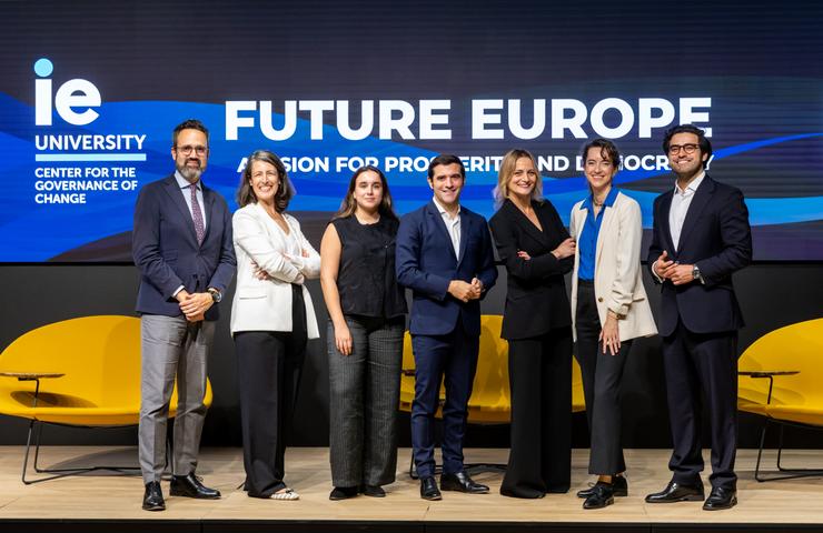 A diverse group of professionals stands together on stage, promoting future initiatives in Europe.