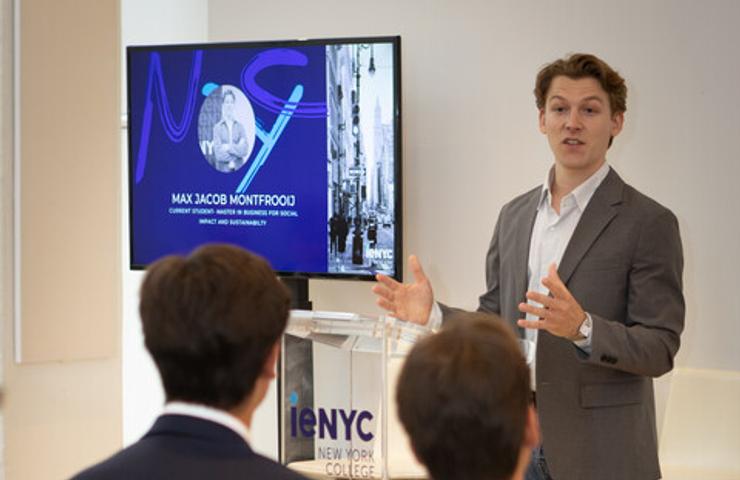 A speaker is presenting in front of an audience at a formal event.