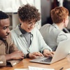 A group of people engaged in a collaborative work environment around a table.